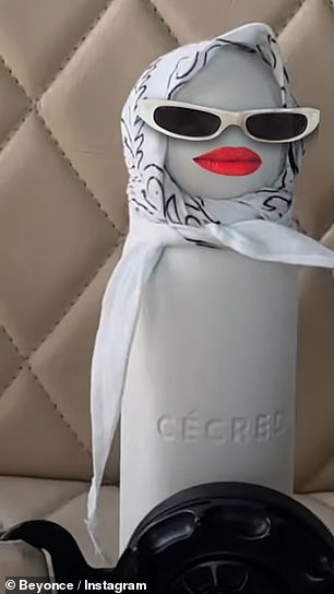 The bottle had a white and black-patterned bandana wrapped around the top, while also sporting sunglasses and red lipstick